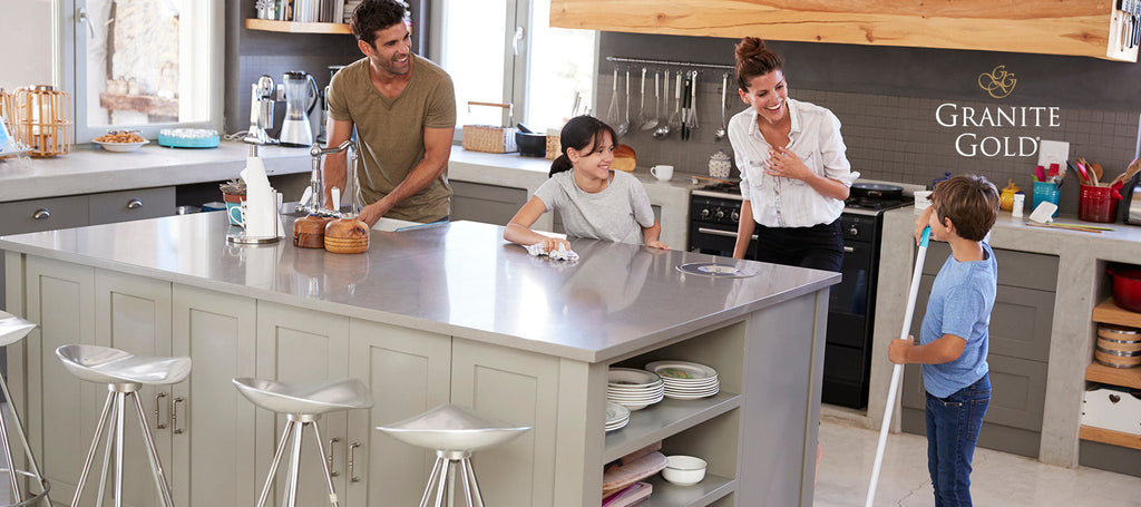 Family standing around granite countertop island in their kitchen